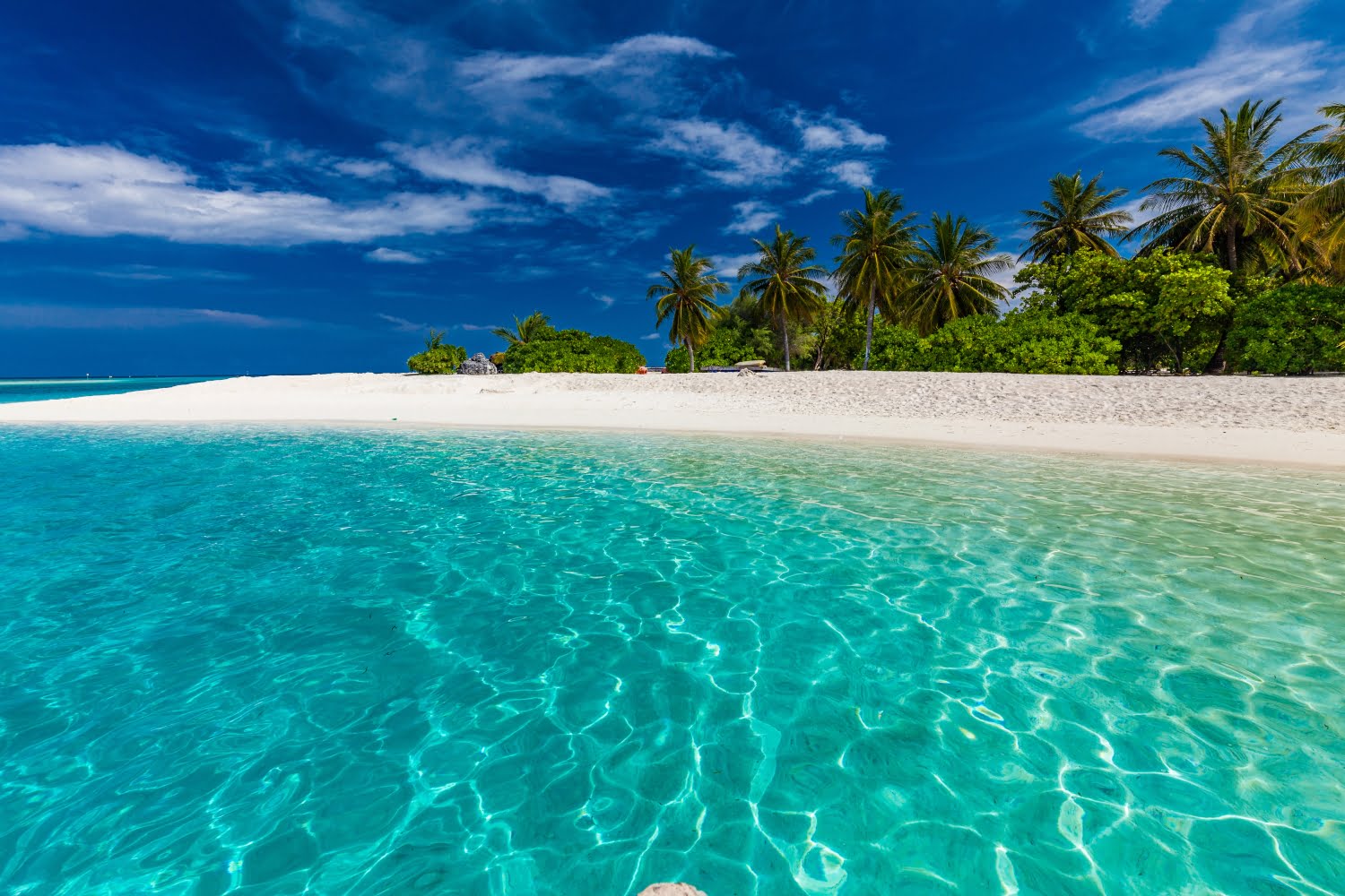 White sandy beach in Maldives with amazing blue lagoon and blue sky