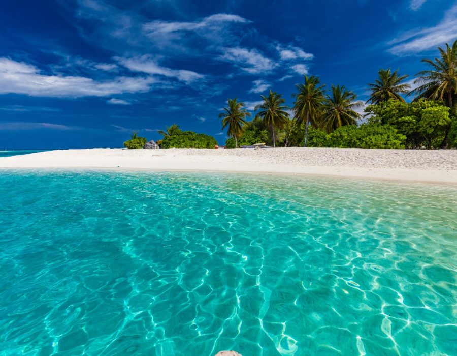 White sandy beach in Maldives with amazing blue lagoon and blue sky